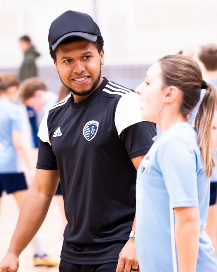 An SBV coach smiling with a player at an indoor session