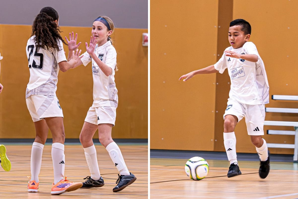 Two SBV players high-fiving on a gym floor, beside an SBV player in the white kit chasing the ball